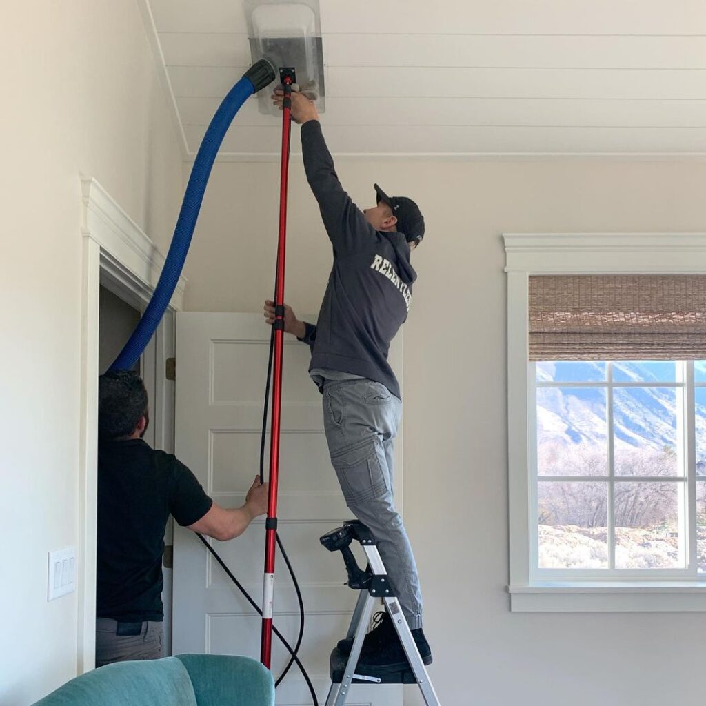 Man performing air duct cleaning in Utah home